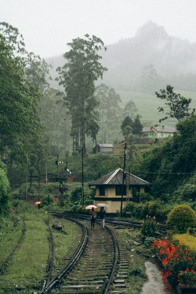 two people walk through rail road in rainy sri lanka weather